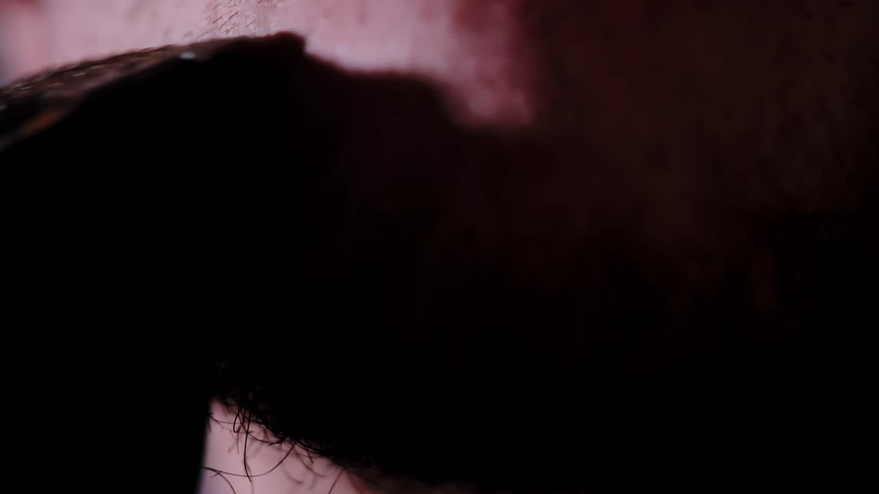 Macro grooming scene showing machine and human skin in tense proximity