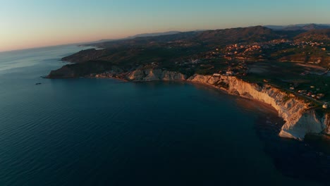 aerial shot over a stunning cliff by the sea on the island of sicily, italy