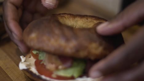 close up shot squeezing a lemon onto a bacon bagel