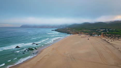 la naturaleza de las olas marinas tormentosas vista por avión no tripulado. mañana nublada el océano lavando arena beige