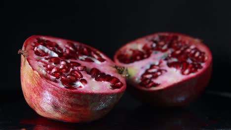 the light moves to the left of the pomegranate on black background