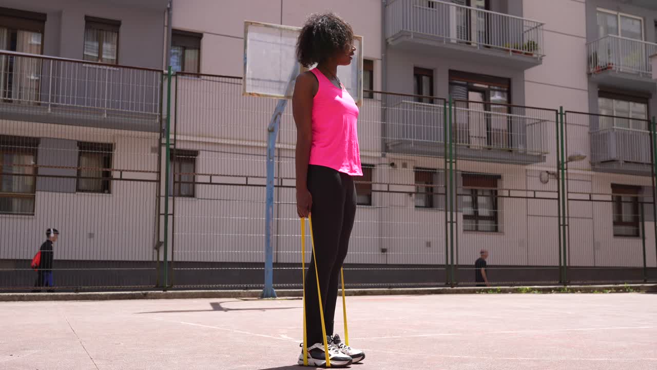 Donna che si allena con fascia di resistenza su un campo da basket