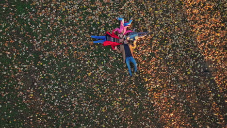 family enjoying autumn leaves in the park