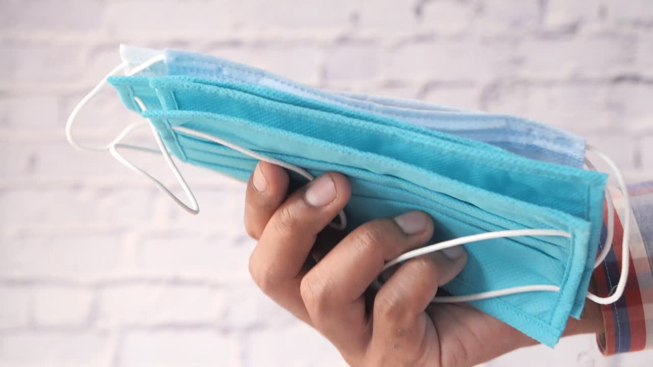 파란색 얼굴 마스크 한 어리를 들고 있는 사람