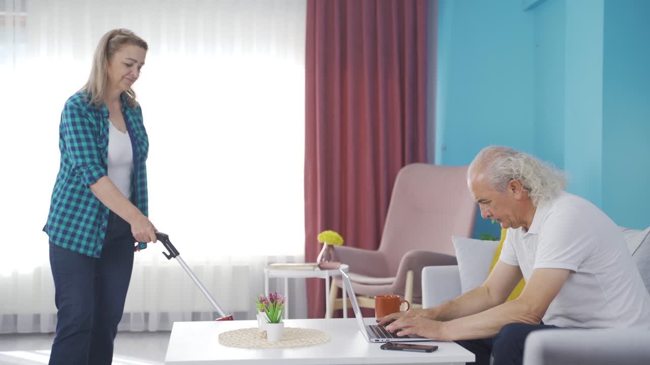 mientras el hombre trabaja en casa, la mujer barre la casa.