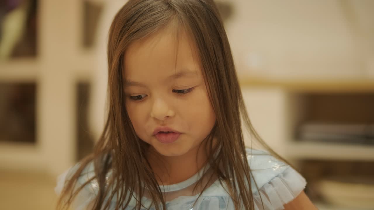 어린 소녀가 집에서 아기 여동생과 즐겁게 놀고 있습니다. 이 순간은 편안한 실내 환경에서 형제자매의 유대감과 가족 사랑을 포착합니다.