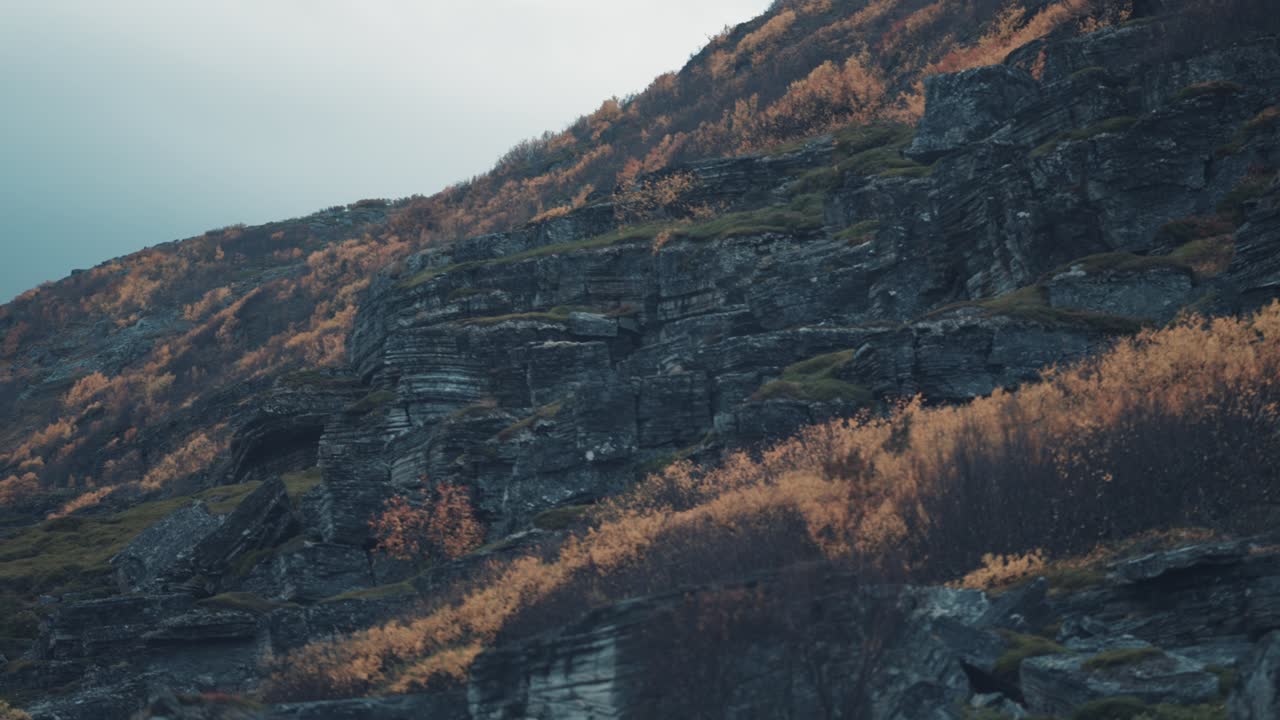 rocas oscuras que se desmoronan cubiertas de escasa vegetación