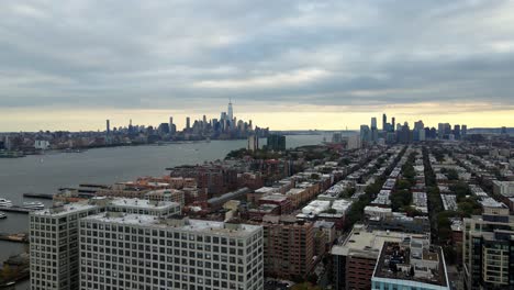 aerial view of the cityscape of hoboken, jersey city, cloudy dusk sky in new york - circling, drone shot