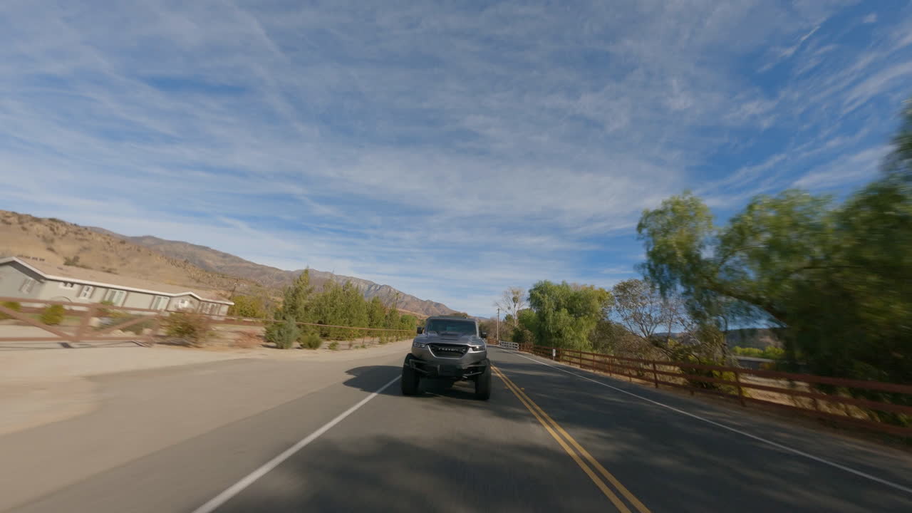 disparo de drones fpv cinemáticos bajos siguiendo un coche de policía a lo largo de una carretera remota