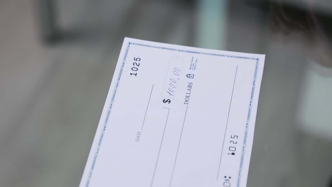 mujer de negocios firma y llena un cheque bancario por mil mil dólares