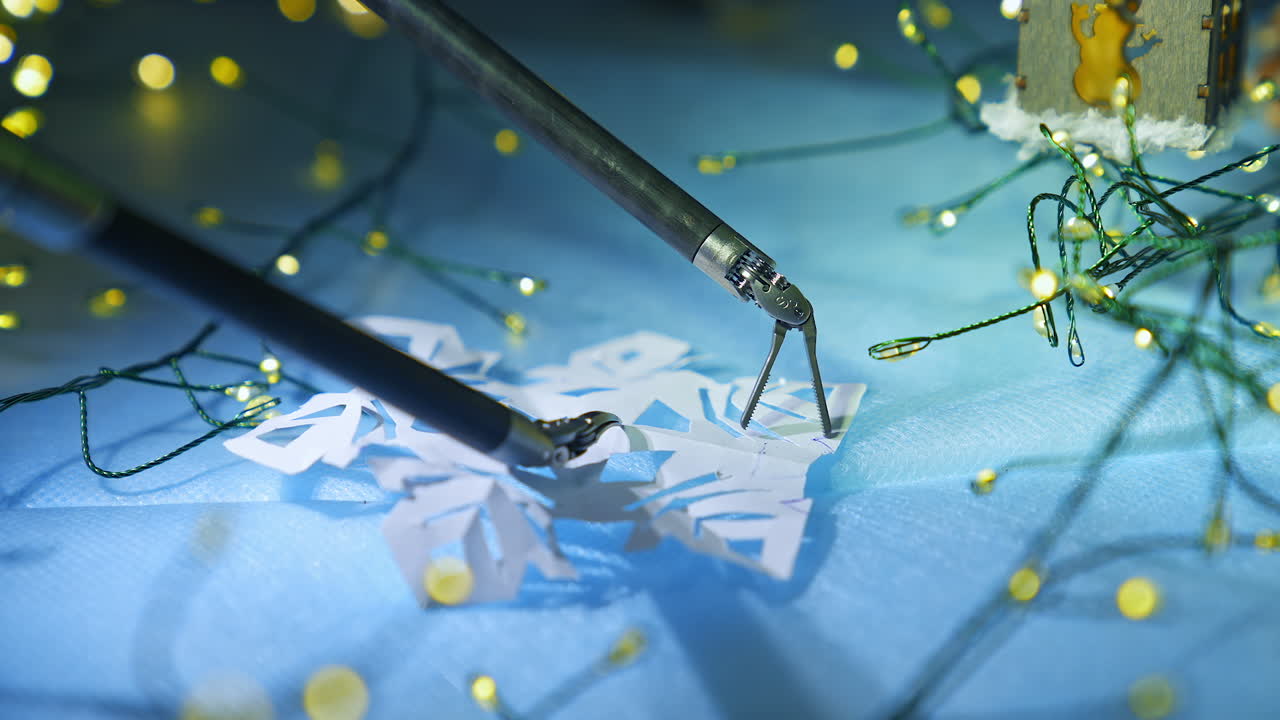 High precision robotic surgery equipment deals with paper snowflake. Decoration lights at the backdrop. Close up.