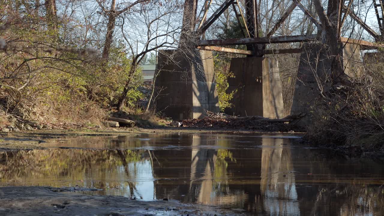 Slow Pan Up from a Stream to Show the Supports of the Pope Lick Railroad Trestle in Louisville Kentucky