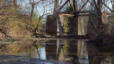 slow pan up from a stream to show the supports of the pope lick railroad trestle in louisville kentucky