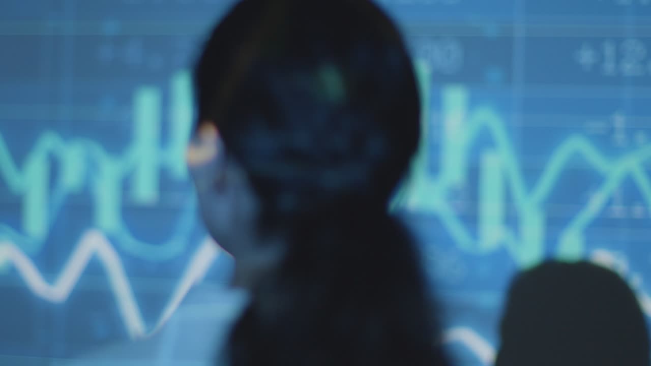 mujer visitando una exposición de arte inmersiva con proyección de datos financieros con gráficos y precios de las acciones 8