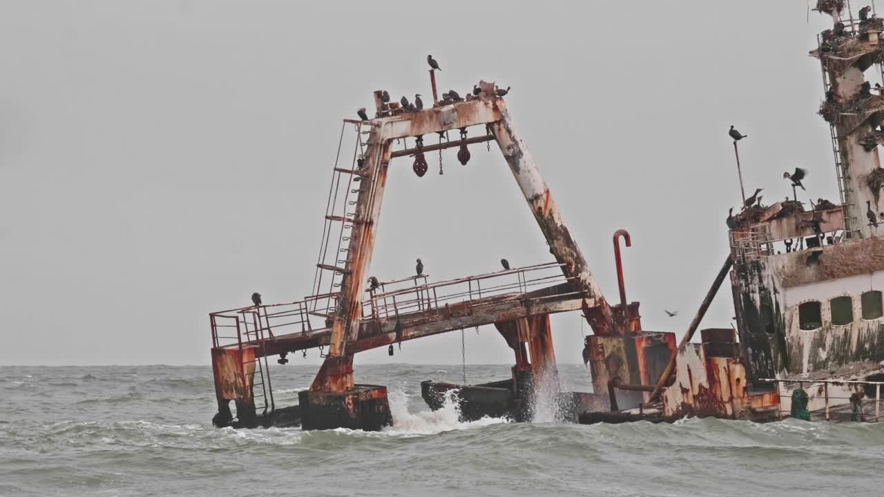 Creepy wrecked trawler ship along Skeleton Coast of Namibia on grey day, Pan