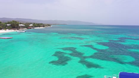 Boat-moored-in-turquoise-sea-waters-of-Playa-Ensenada-beach,-Dominican-Republic