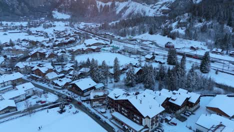 picturesque mountain town in snowy valley below the alps at dusk