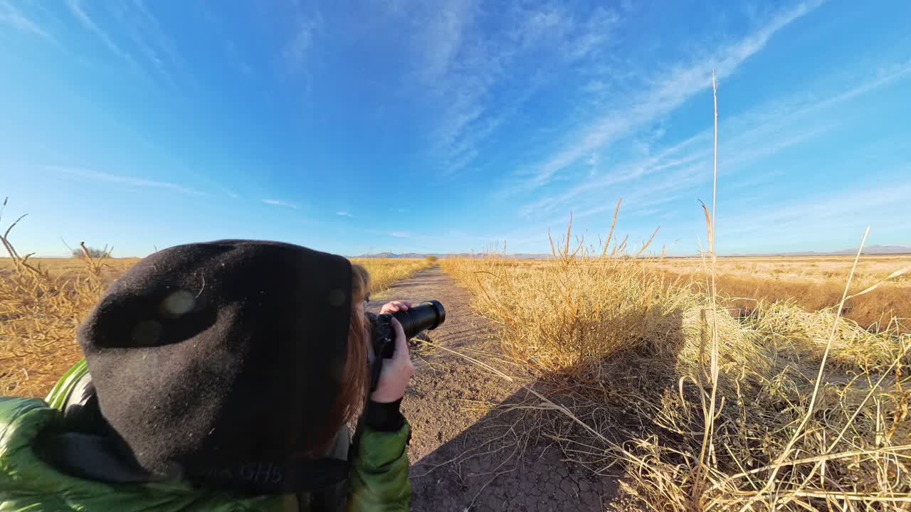 Photographer working in winter dry golden grasslands of Arizona USA.