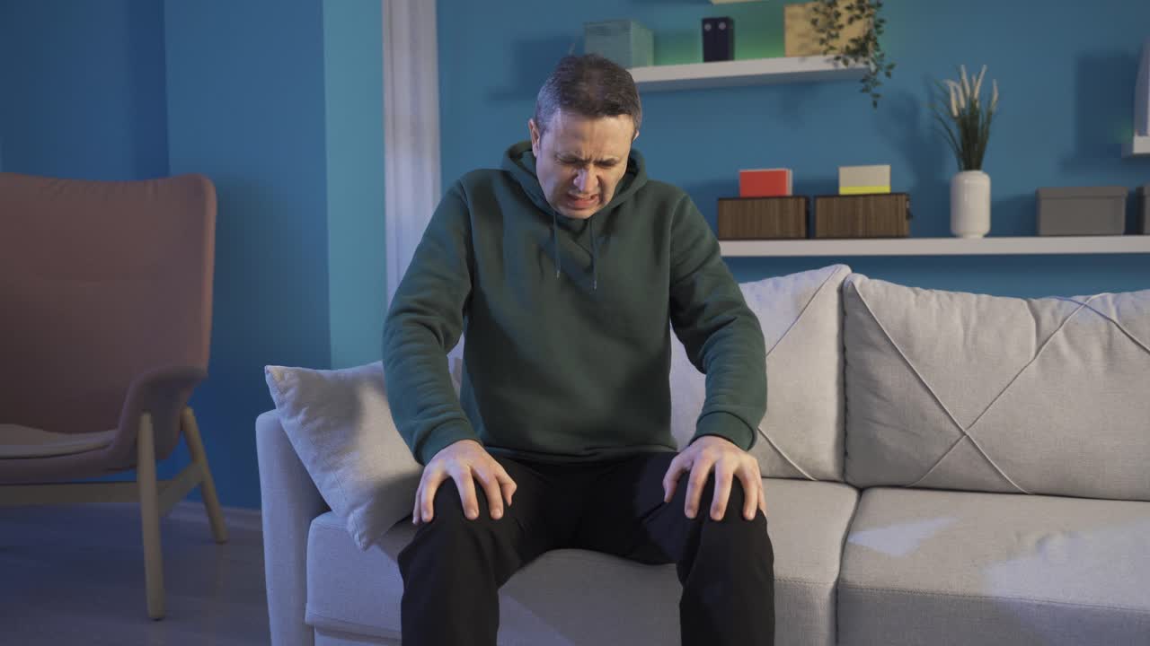 Mature man with severe rheumatism rubbing his knees.