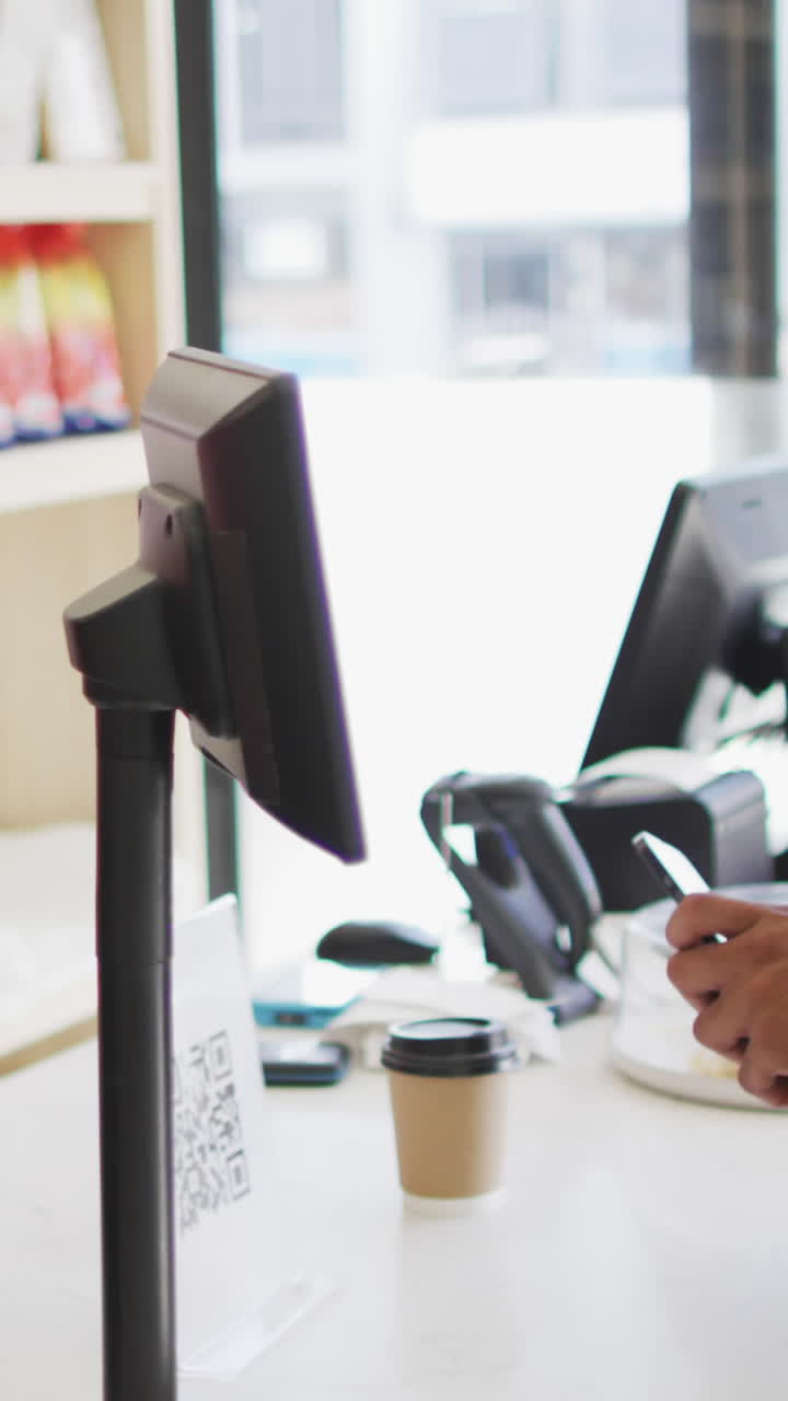 video de un hombre biracial feliz pagando con un teléfono inteligente por café a una camarera biracial