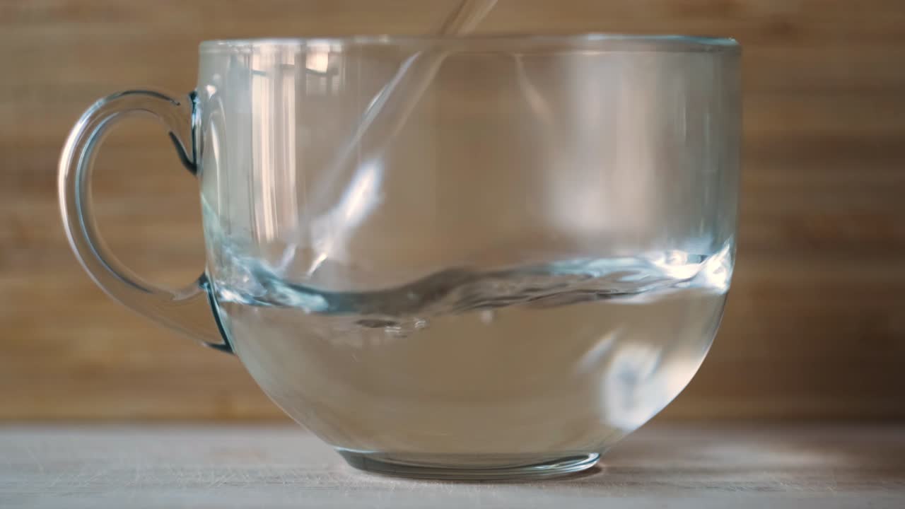vertiendo agua en una taza de vidrio