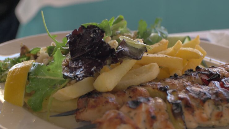Comiendo con pollo, patatas fritas crujientes y ensalada