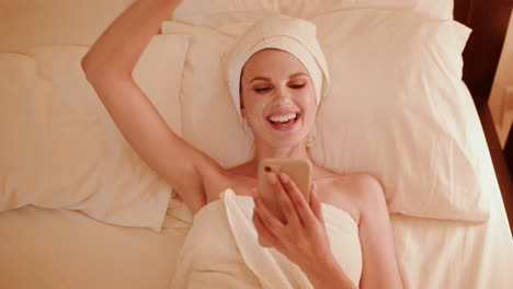 woman relaxing with smartphone on bed