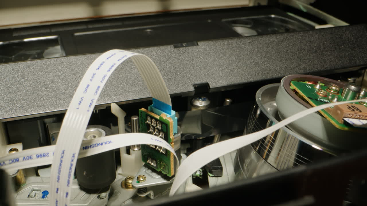 Old video recorder inside close-up, VHS. Retro player in neon blue light, vintage video cassette broadcasting, audio tape.