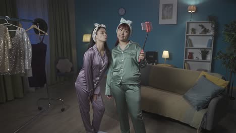 two women in pajamas taking a selfie