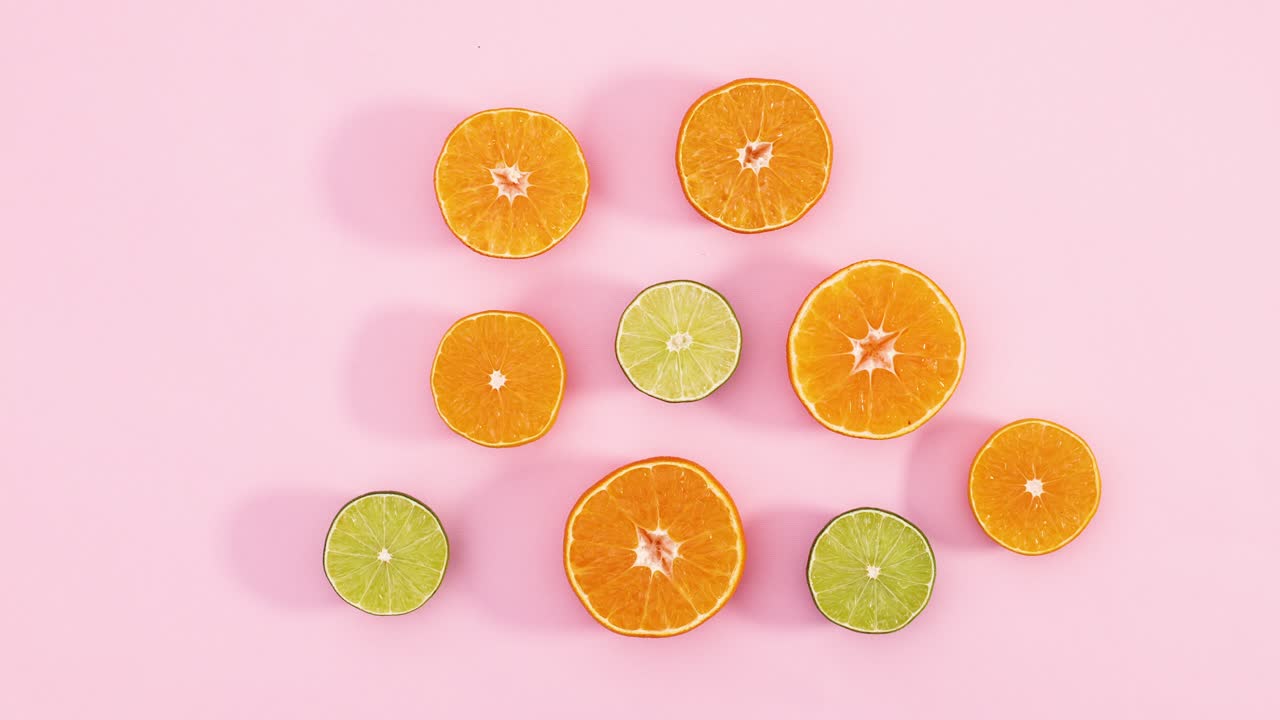 Slices of oranges and limes appear on pastel pink theme. Stop motion