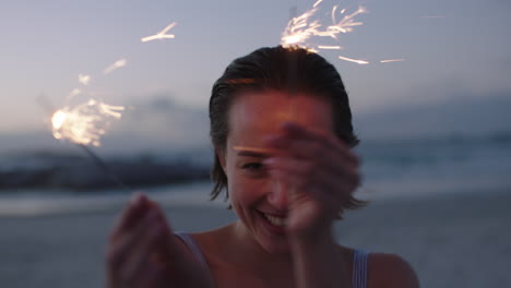 atractiva mujer joven sosteniendo bengalas bailando en la playa alegre feliz