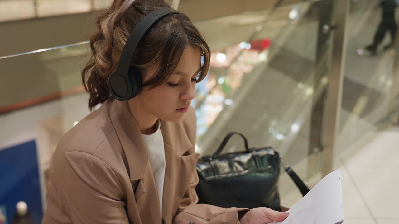 mujer examinando documentos, joven centrándose en materiales de estudio, mujer analizando cuidadosamente sus documentos y apuntes, mujer revisando diligentemente su material educativo y profesional