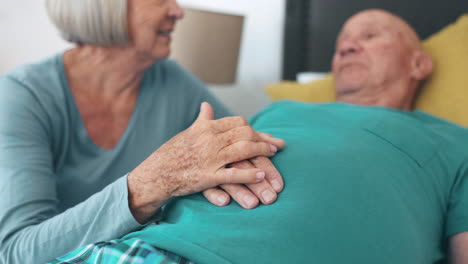 teniendo las manos, la pareja mayor y la cama con empatía