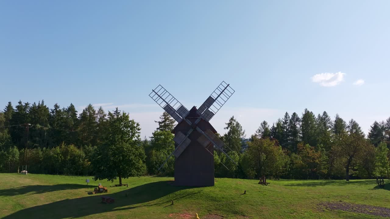 Prise de vue par drone d'un moulin à vent historique s'élevant au-dessus de champs d'un vert éclatant