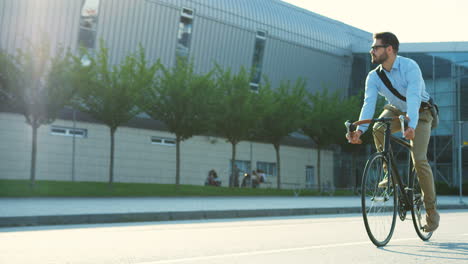 handsome man coming back home from work riding a bicycle