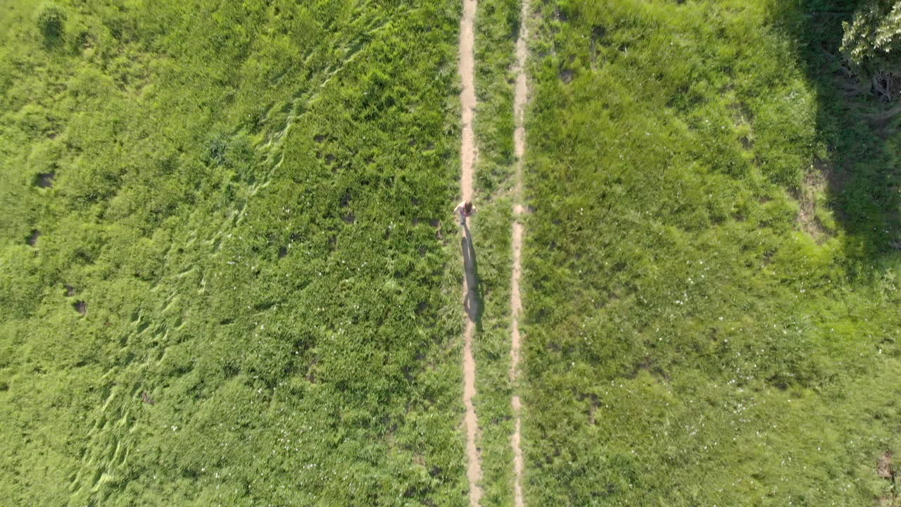 antena de una joven corriendo por un sendero forestal al atardecer