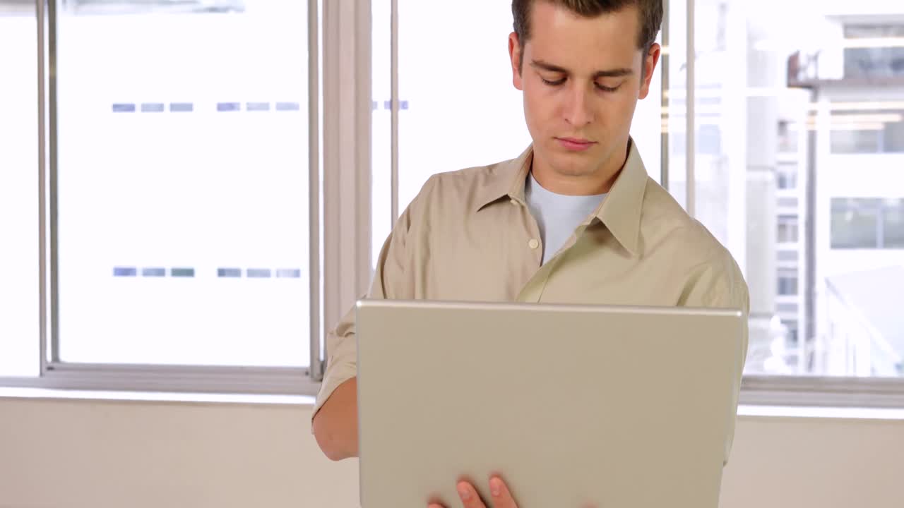joven hombre de negocios severo usando su cuaderno