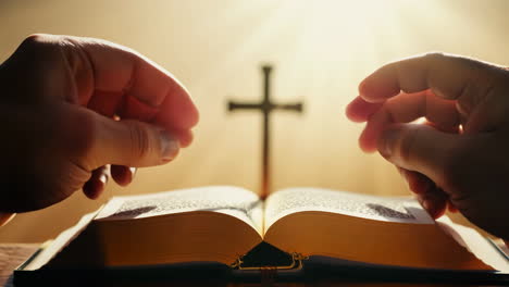 open bible with cross in background illuminated by soft light