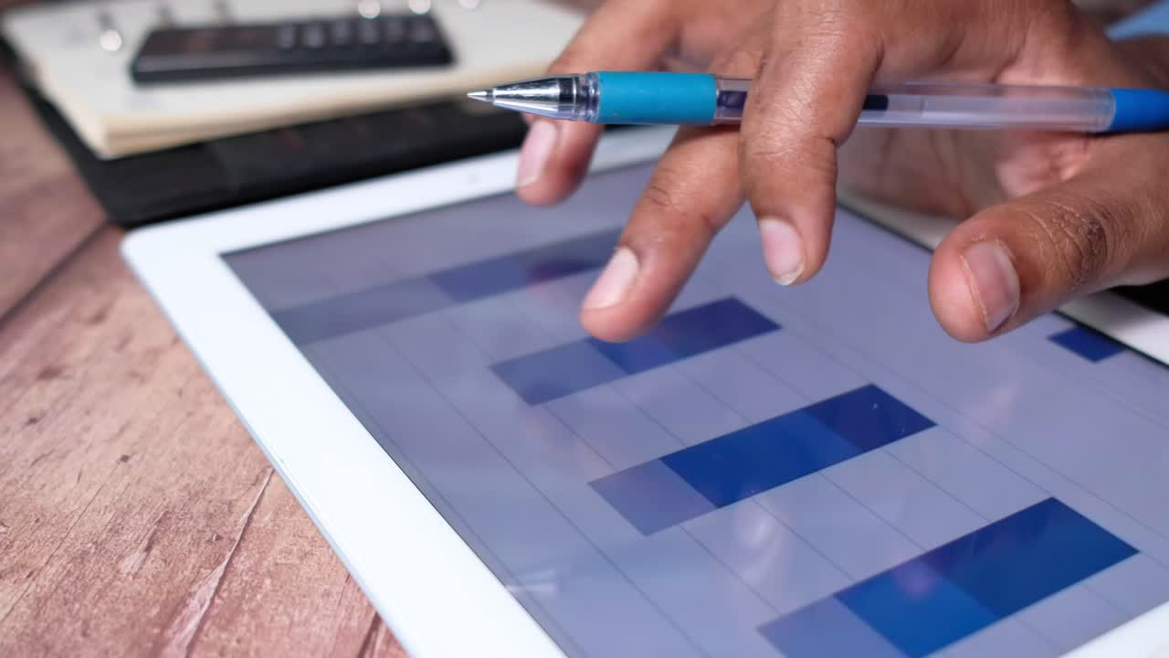 persona analizando datos financieros en una tableta