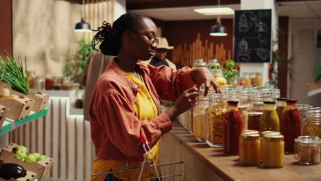 vegan client examining types of pasta on sale at zero waste store