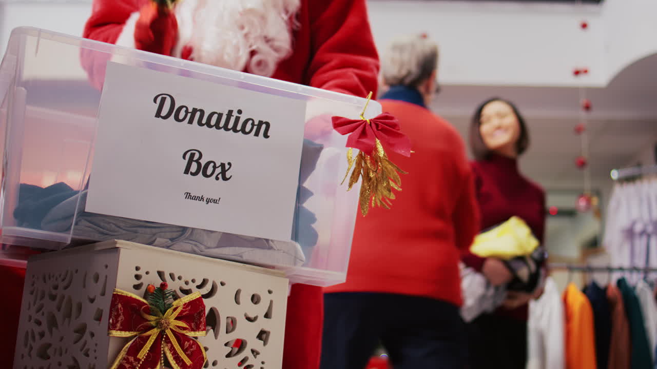 fotografía de cerca de la caja de caridad en la tienda de ropa adornada de xmas. comunidad cariñosa tocada por el espíritu navideño donando ropa para esfuerzos filantrópicos durante la temporada festiva de vacaciones