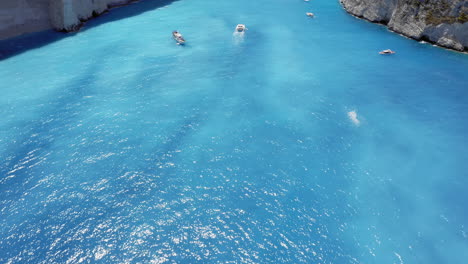 Aerial:-Slow-reveal-of-Navagio-beach-with-the-famous-wrecked-ship-in-Zakynthos,-Greece-at-summer