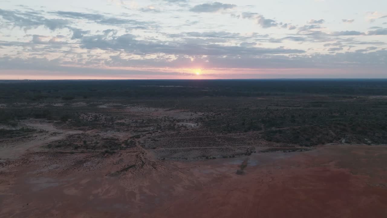 Gün doğumunda uzak Avustralya taşrasını gösteren aşağı eğimli drone görüntüsü.