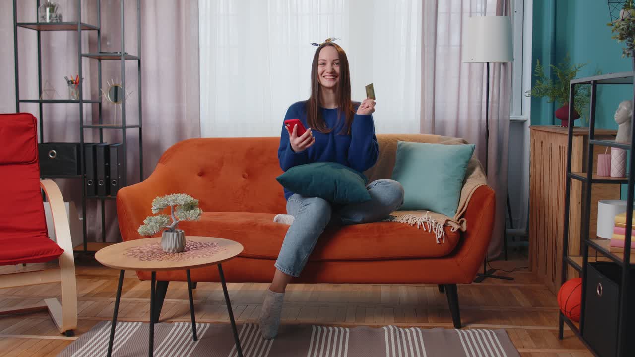 mujer sentada en casa usando tarjeta de crédito bancaria y teléfono inteligente mientras transfiere dinero a compras en línea