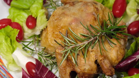 baked chicken with salad and tomato rotating on dish