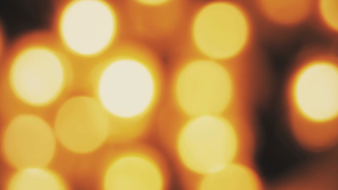 Abstrakt cirkulær gylden gnistre glitter bokeh med flydende bevægelse på sort baggrund, til lykønskning, hilsen, fest og godt nytår
