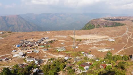 Pequeña-Aldea-Remota-En-La-Cama-Plana-De-La-Cima-De-La-Montaña-Con-Un-Cielo-Brillante-Por-La-Mañana-Desde-Un-Video-De-ángulo-Superior-Tomado-En-Nongnah-Meghalaya-India