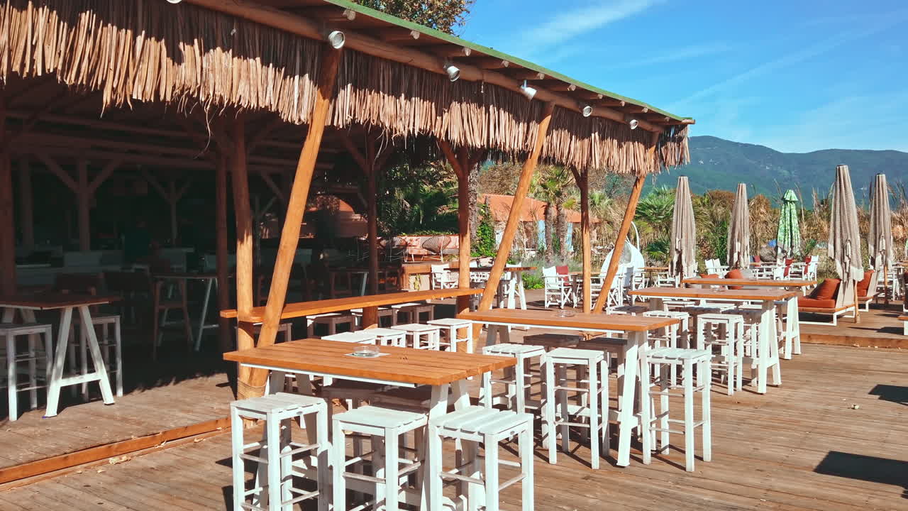 Restaurant on the aegean coast in Greece. Seats, tables, umbrellas, tent
