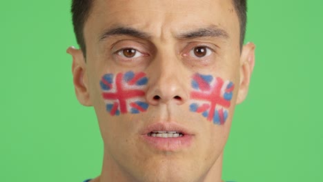 man with a british flag painted on the face smiling