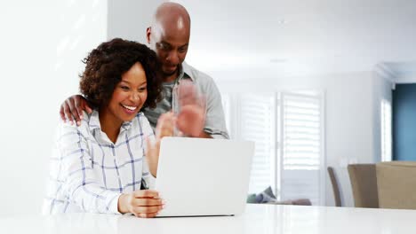 Couple-using-laptop-at-home-4k